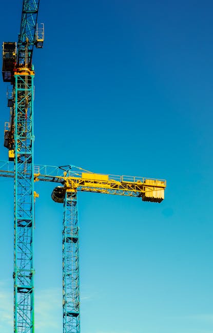 Construction site with cranes and urban skyline in background